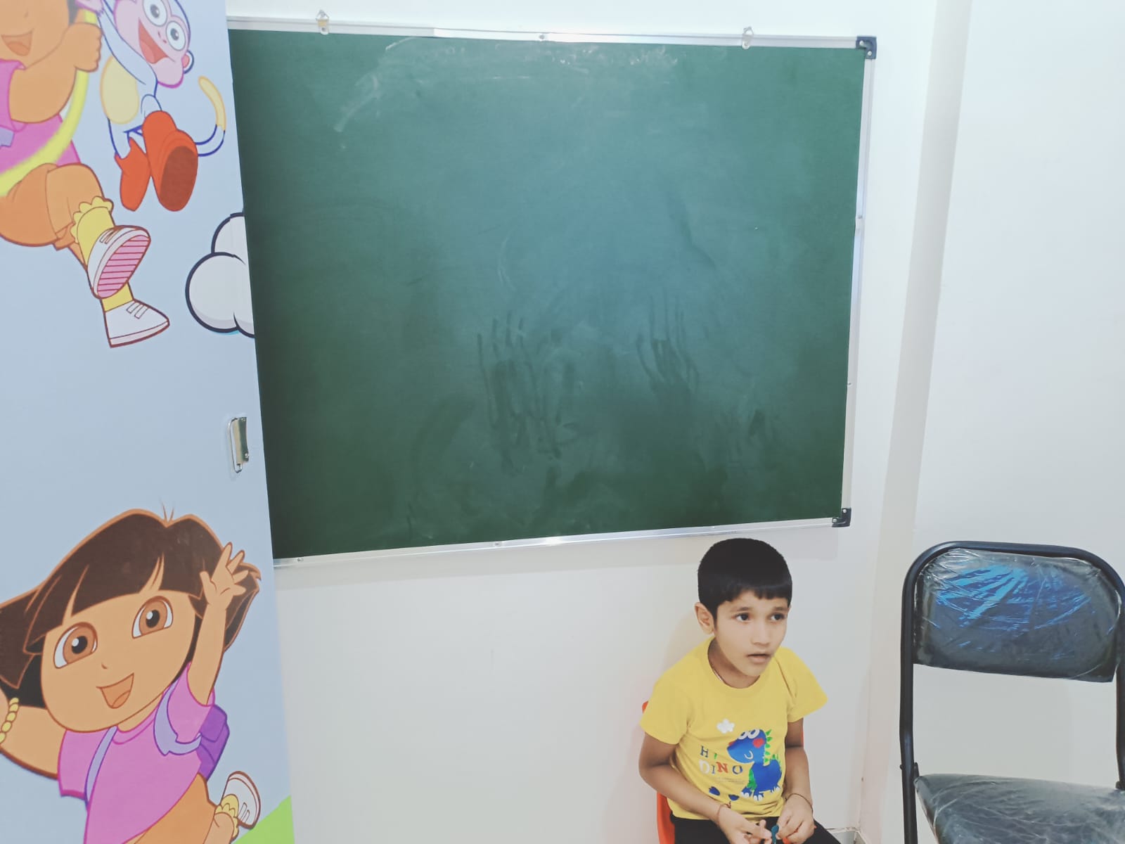 A Willow Wings classroom with chalkboard and Dora wall mural